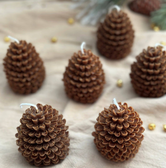 Pine Cone Candles arranged on neutral cloth by belle aura