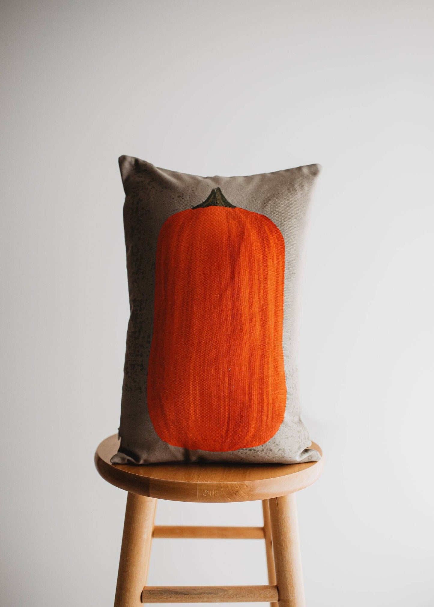 Pumpkin lumbar pillow by Belle Aura on stool