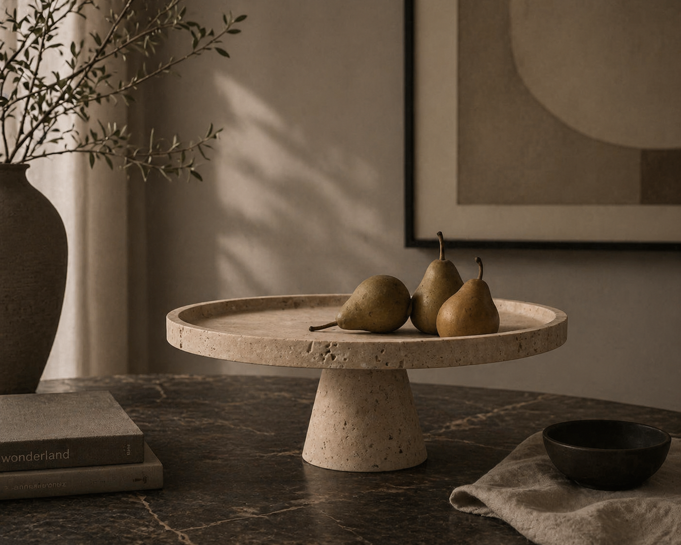 Decorative setting with a stone pedestal tray holding pears, a vase with branches, and a framed abstract painting.