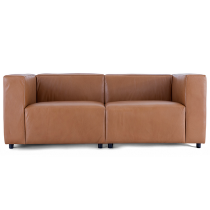 A straight-on view of the Aaran sofa in cognac top grain leather, showing its modern boxy design and deep seats.