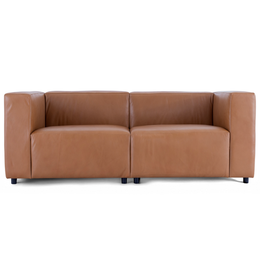 A straight-on view of the Aaran sofa in cognac top grain leather, showing its modern boxy design and deep seats.