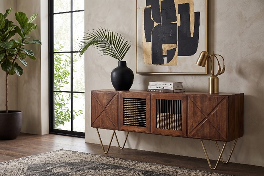 The warm walnut Aurelia Sideboard used as a luxury media console, styled with a brass lamp, palm vase, and mid-century modern art.