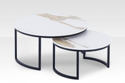 The Concord solid marble nesting tables in a black finish spread apart, highlighting the authentic stone veining and dynamic beveled edges.