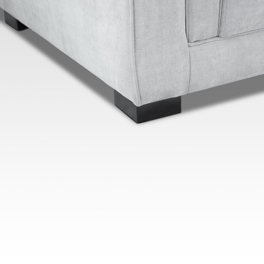 A close-up of the Elysian sofa’s dark steel block leg, emphasizing the modern industrial contrast with the steel gray textured fabric.