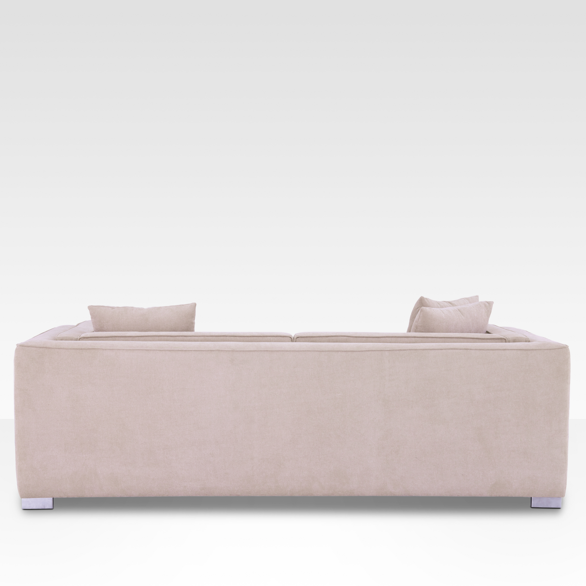 sofa, showing the continuous Seaside Sand fabric wrap and modern polished chrome legs.