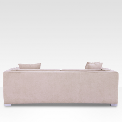 sofa, showing the continuous Seaside Sand fabric wrap and modern polished chrome legs.