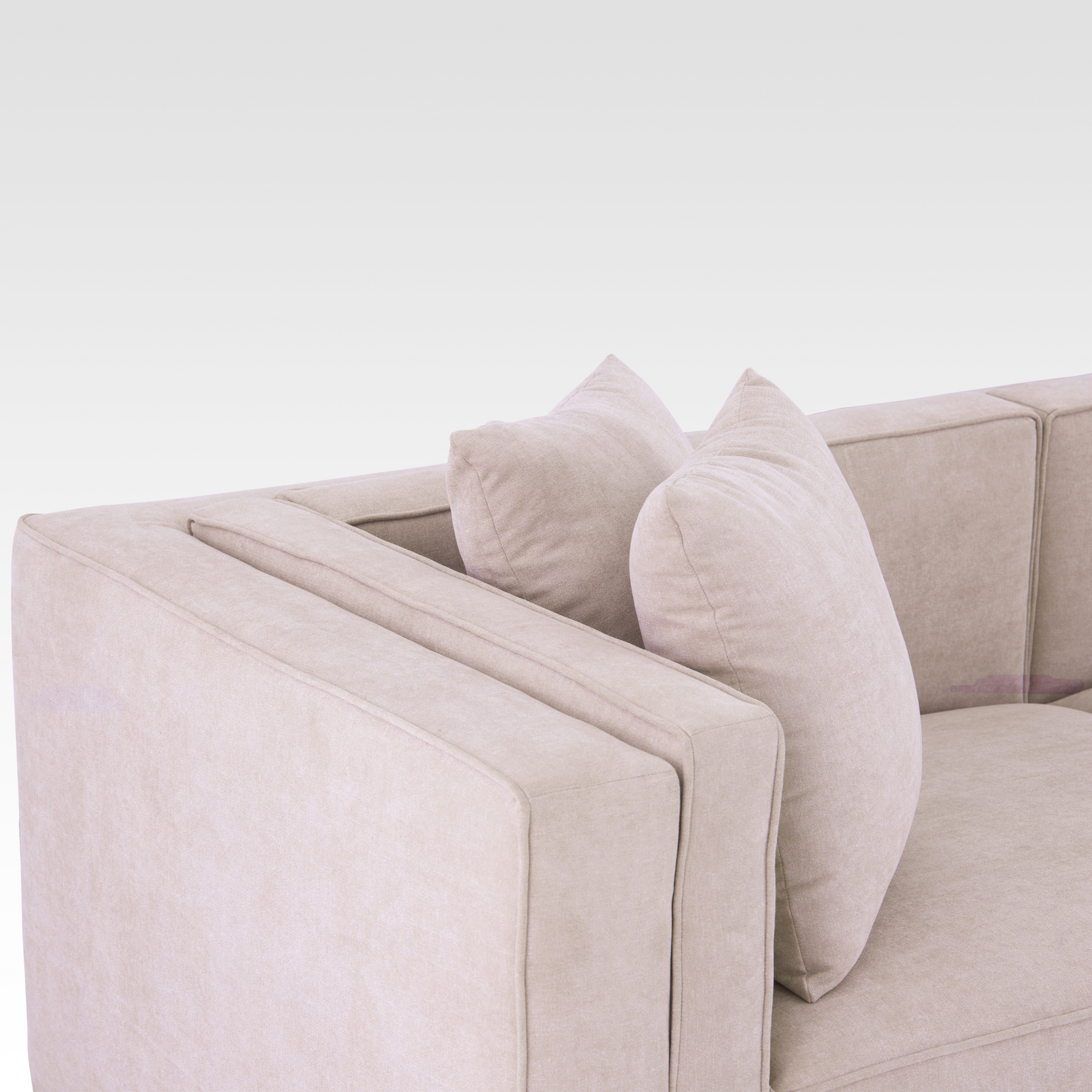 A close-up of the Elysian sofa's unique inset track arm and textured Seaside Sand upholstery.
