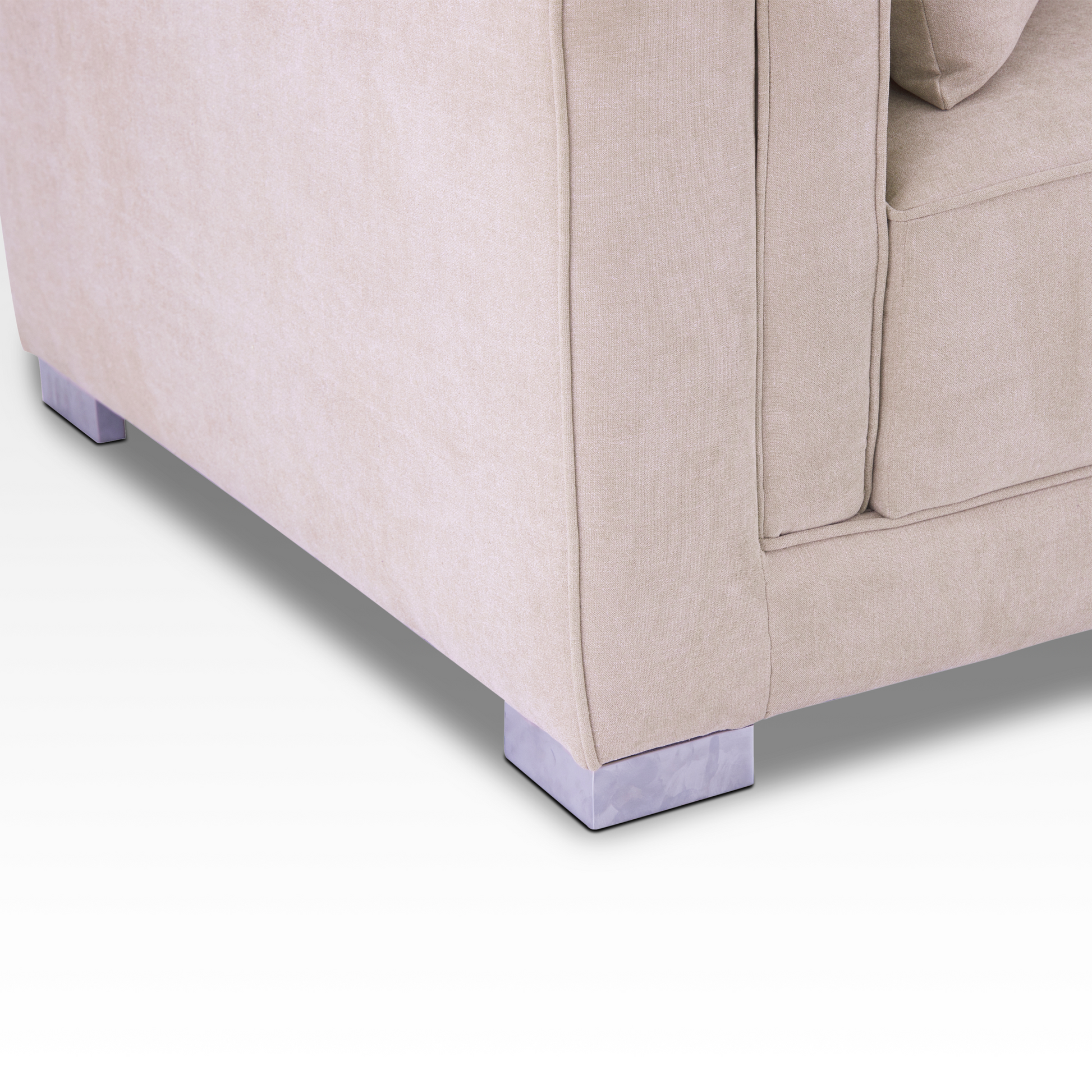 A detailed view of the Elysian sofa corner showing the warm sand-toned fabric and polished chrome block legs.