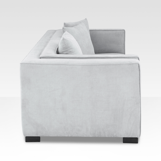 A side profile of the Elysian sofa showing the deep geometric frame and the low-profile dark steel legs.