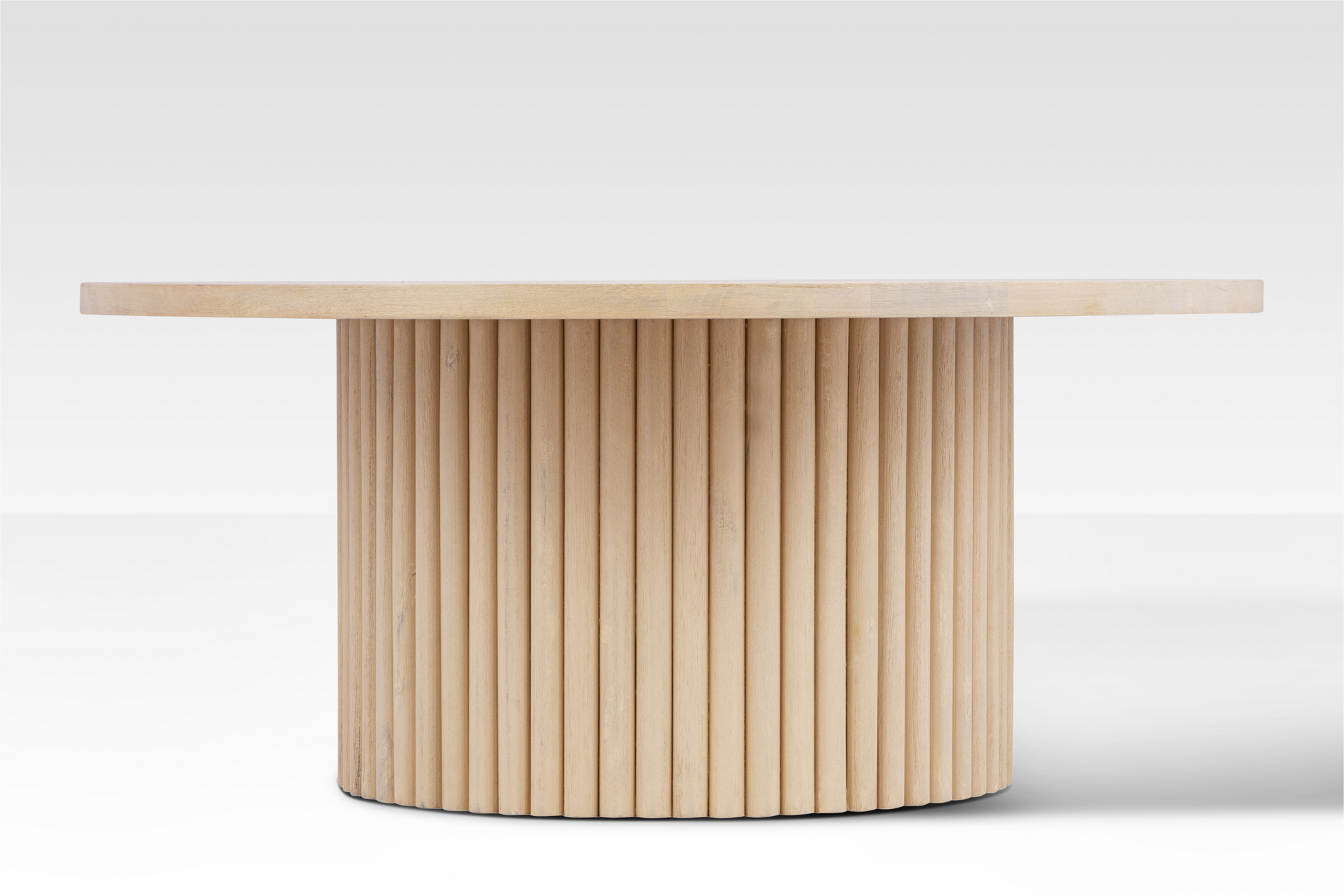 Straight-on profile of the Grove Coffee Table highlighting the rhythmic vertical rods of the fluted pedestal base.