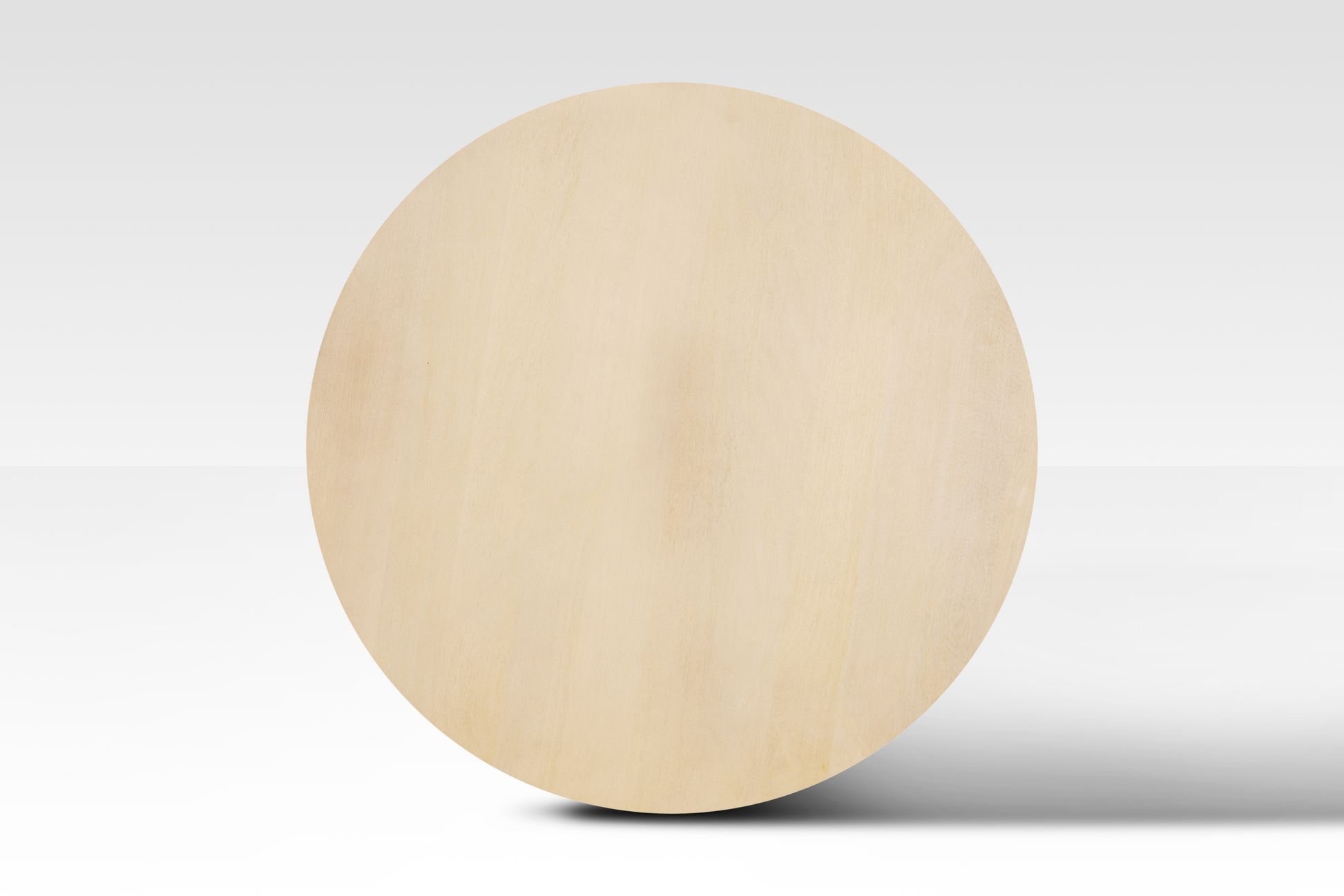 A perfectly circular overhead view of the Grove Coffee Table in natural wood, showcasing its smooth minimalist surface and organic grain.