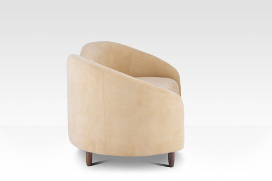 A side view of the Aaria sofa showing the kidney-bean curve and the dark brown wood legs.