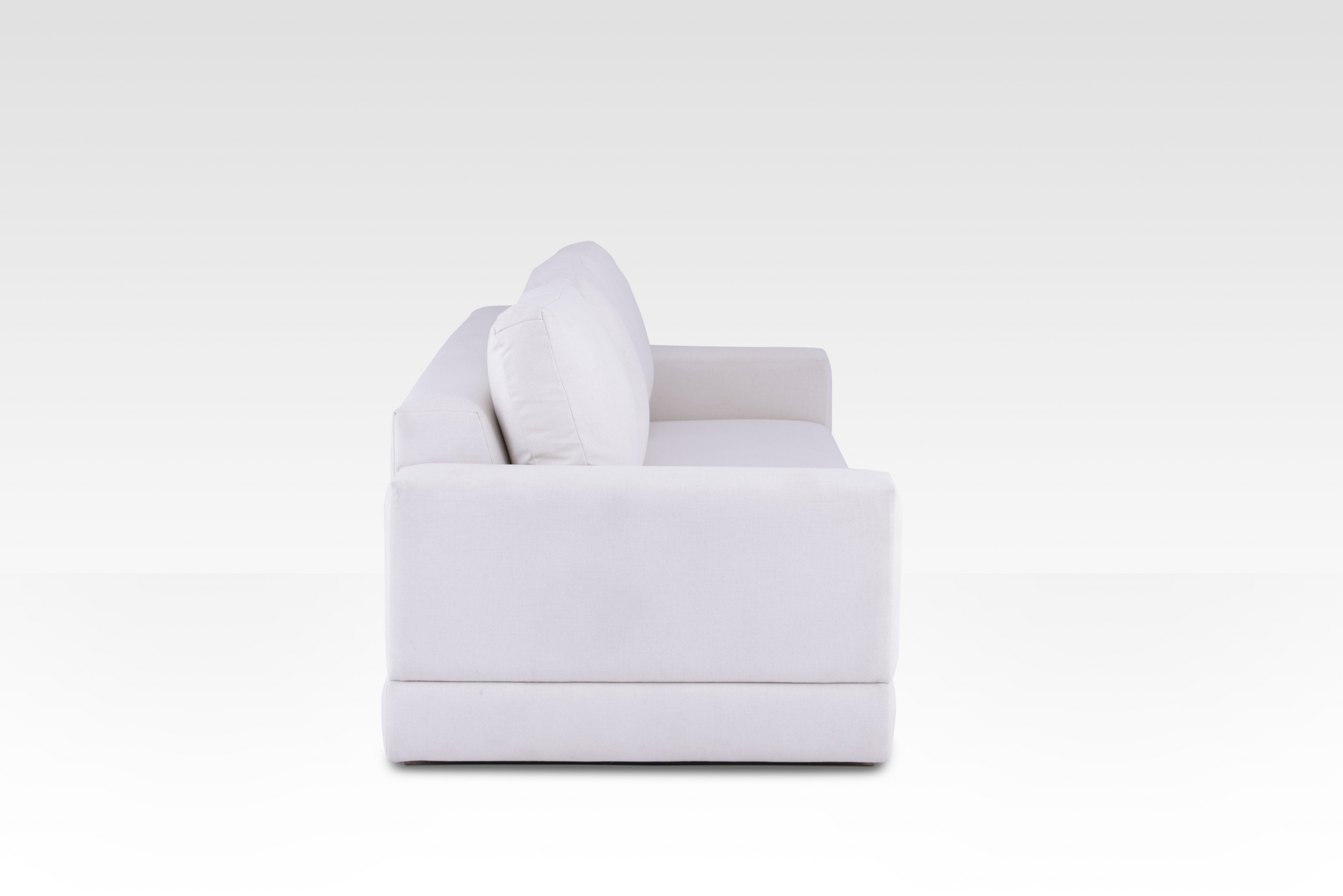 A side profile of the Vanilla Cream Kyra sofa, showing its deep seat and wide track arms.