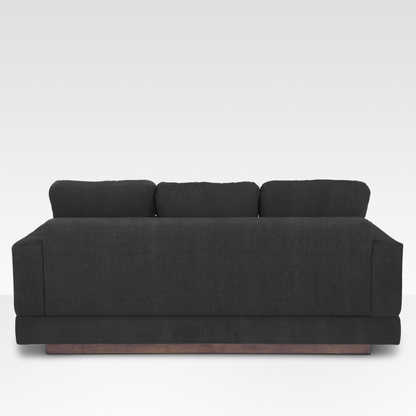 The rear view of the Kyra sofa, showcasing the continuous Pewter fabric wrap and the solid wood base at the floor.