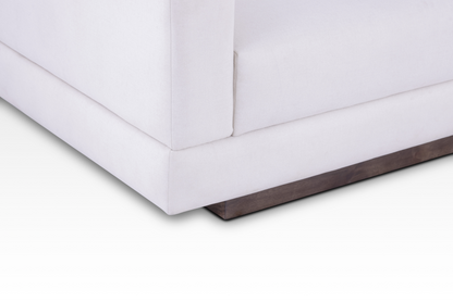 A focused close-up of the solid wood plinth base in a rich walnut finish on the Vanilla Cream Kyra sofa.