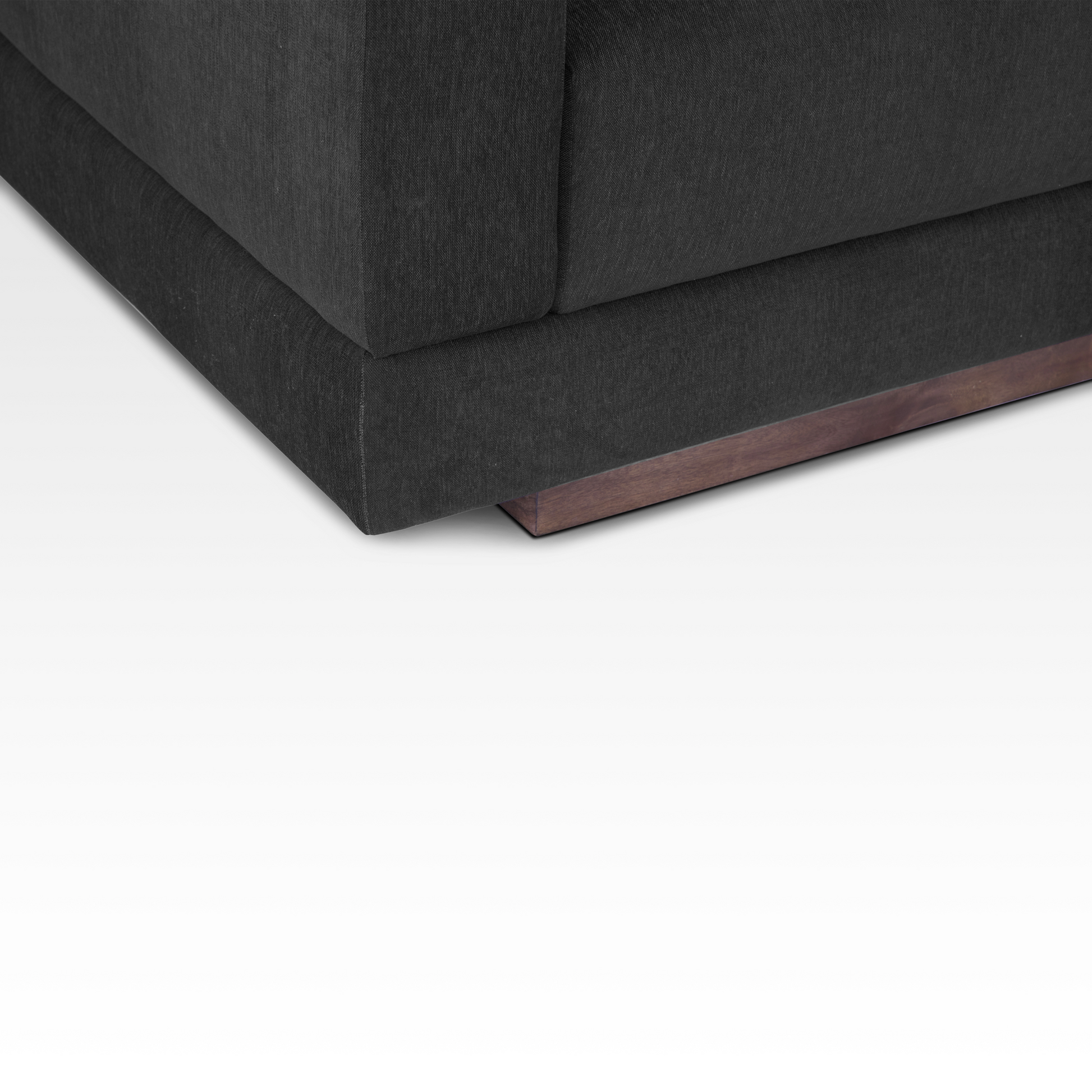 A close-up of the Kyra sofa's solid wood plinth base, emphasizing the natural wood grain and floating architectural look.