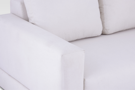 A macro detail view focusing on the wide track arm and the tight weave of the Vanilla Cream textured fabric.