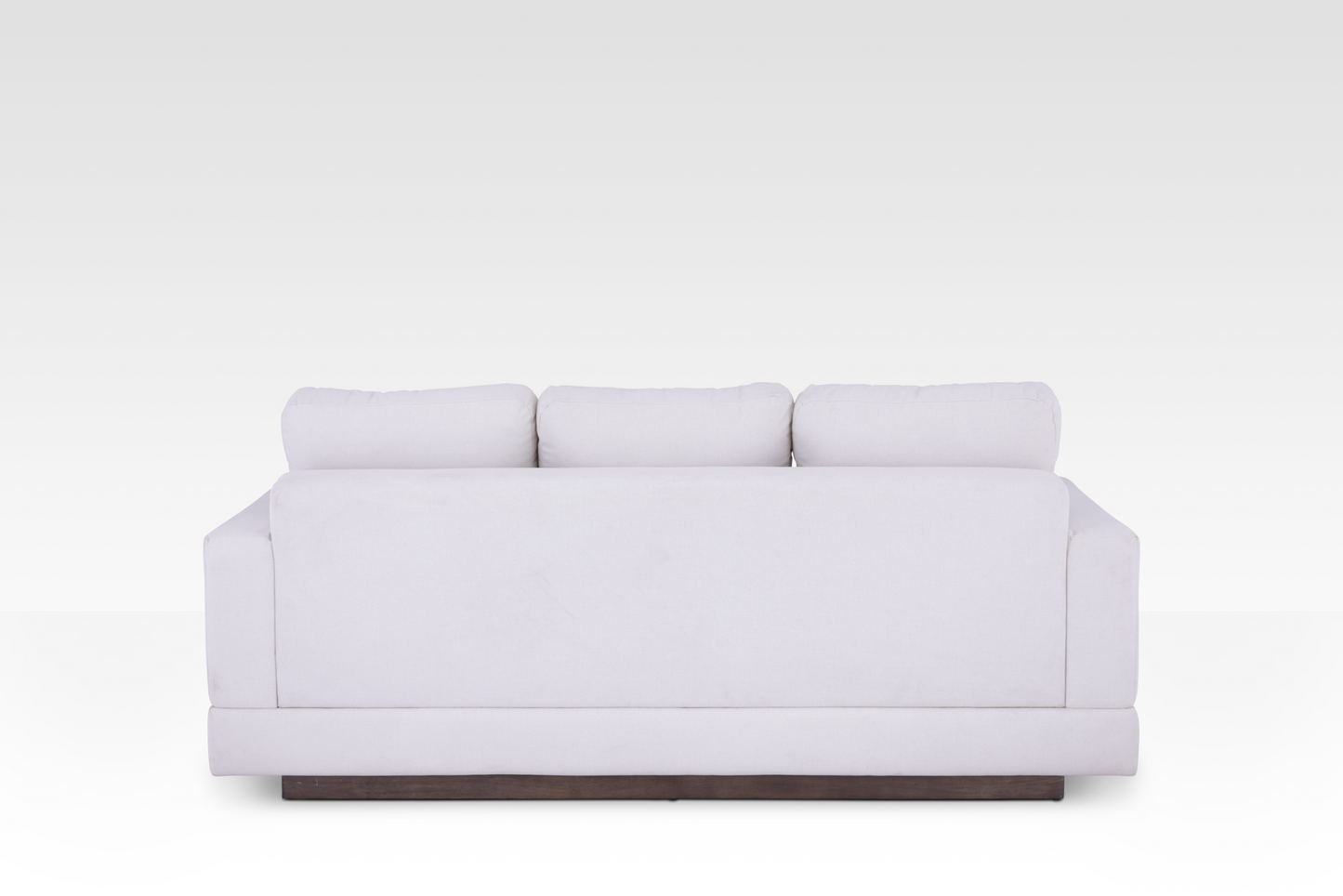 The clean rear view of the Kyra sofa, showing the continuous Vanilla Cream fabric wrap and the elegant solid wood base.