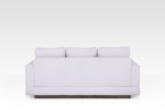 The clean rear view of the Kyra sofa, showing the continuous Vanilla Cream fabric wrap and the elegant solid wood base.