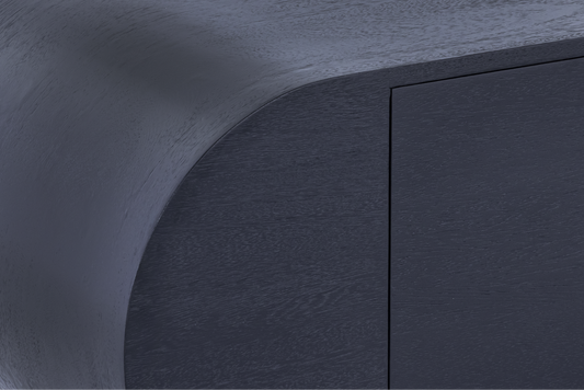 Detail of the soft-modern capsule curve and natural mango wood texture on the edge of the Mira storage console.