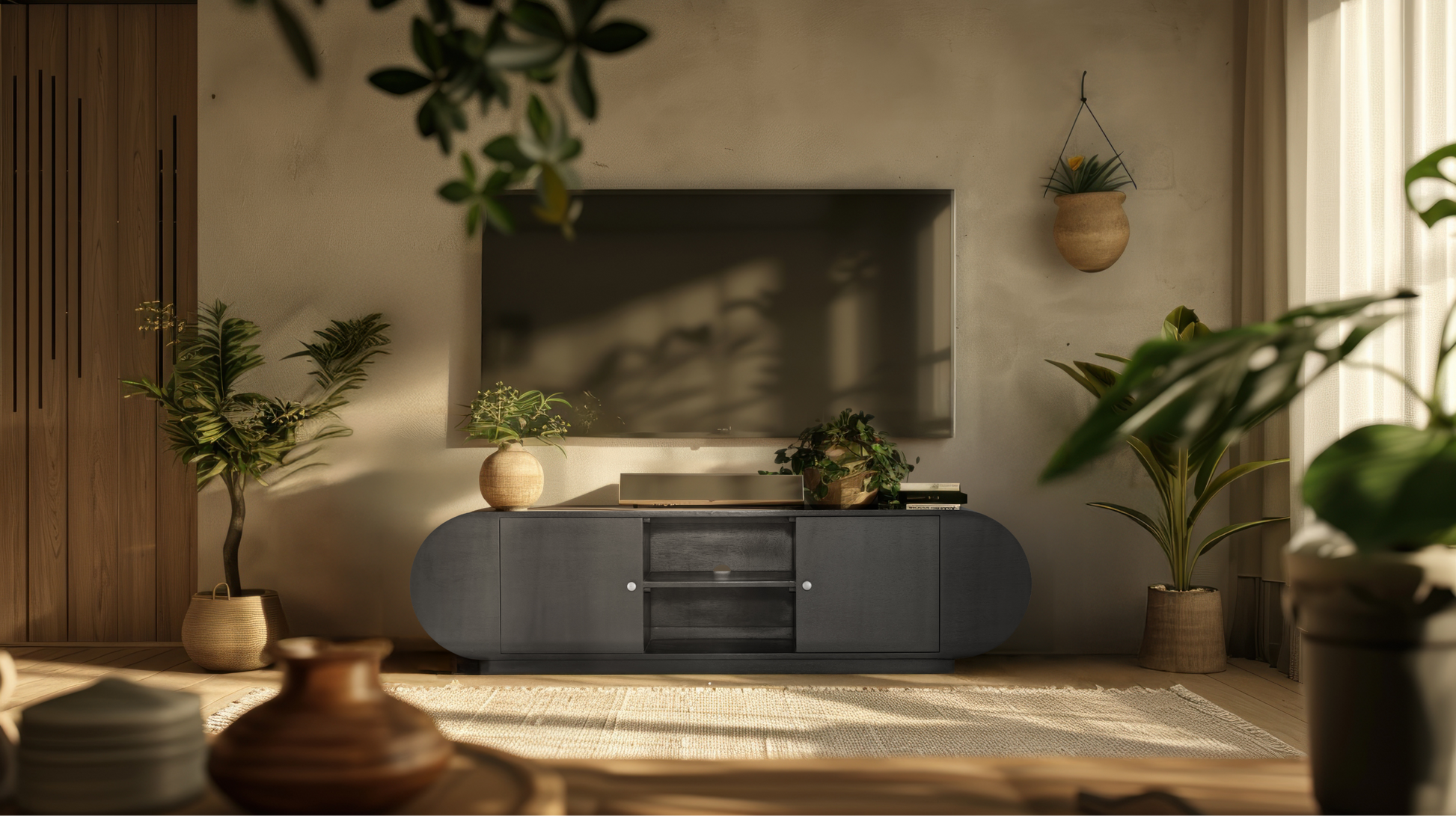 The low-profile Mira Sideboard utilized as a modern media console, with a flat-screen television on top and a textured wall backdrop.
