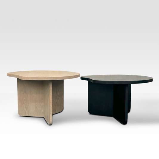 A pair of Nook nesting coffee tables in natural oak and matte black wood, featuring organic cloud-shaped tops and a tri-vane base.