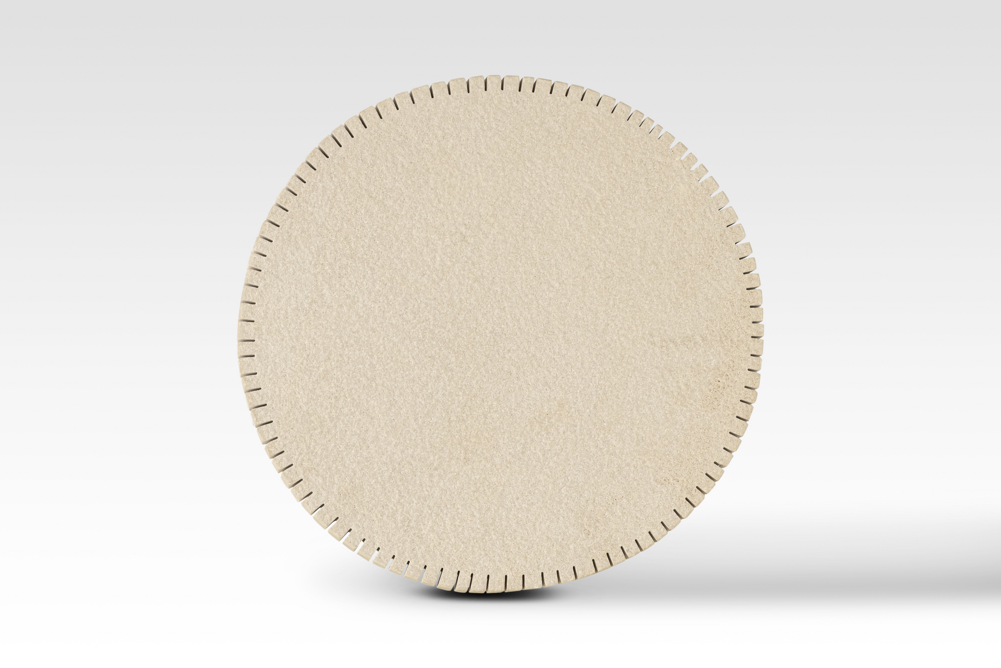 A perfectly circular overhead view of the Oasis End Table’s notched edge sandstone top, showcasing the architectural 'cog-style' perimeter and natural stone texture.