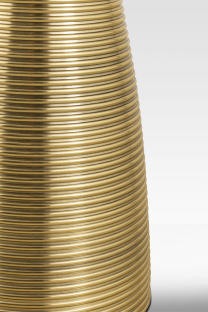 A close-up detail of the Oasis End Table’s aluminum pedestal, highlighting the continuous horizontal ribbing and metallic gold finish.