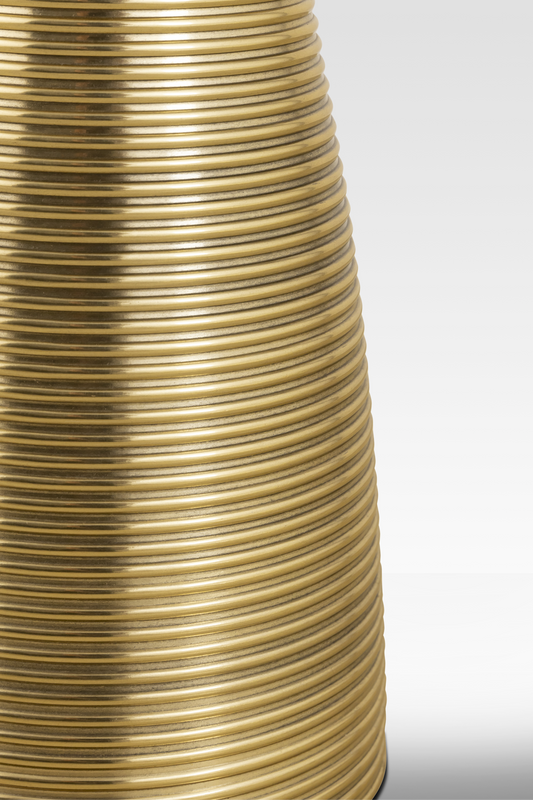 A close-up detail of the Oasis End Table’s aluminum pedestal, highlighting the continuous horizontal ribbing and metallic gold finish.