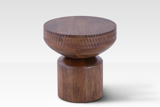 An angled view of the solid mango wood Orbit End Table, featuring a hand-carved textured band and a soft hourglass silhouette in a rich walnut finish.