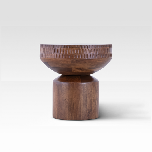 A front profile of the Orbit End Table highlighting its smooth, curved volumes and the detailed hand-carved ridge pattern around the center.