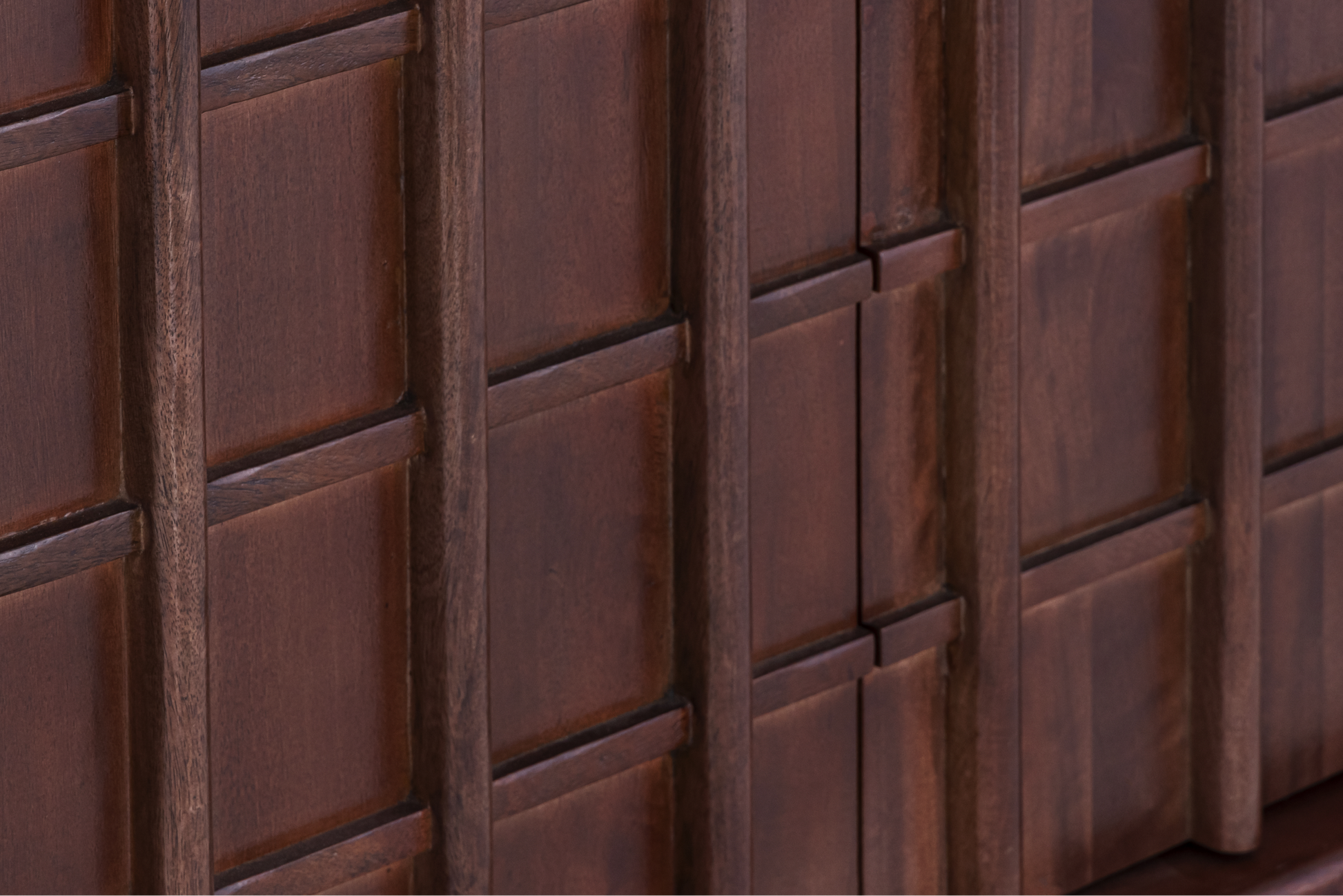 Macro shot of the geometric relief pattern and natural mango wood grain on the Quattro Sideboard door fronts.