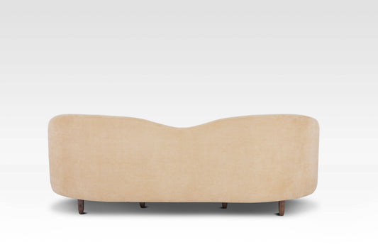 The back of the Aaria sofa, showing the smooth, continuous curve of the frame and the cream upholstery.